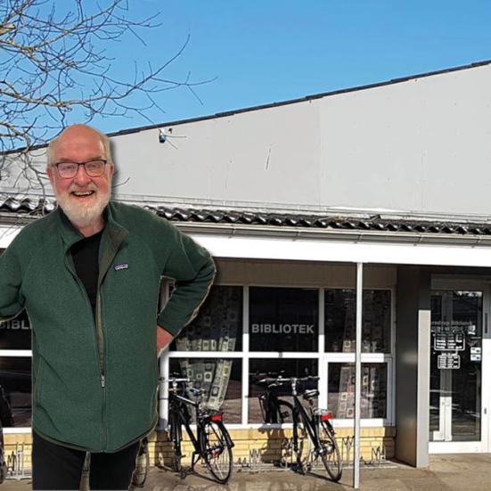 Portræt af Mogens Yde på baggrundsfoto af Terndrup Bibliotek